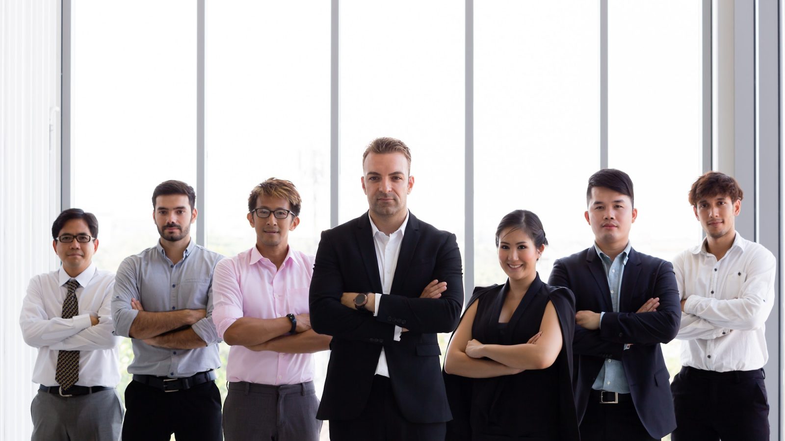 Group of business people with arms crossed in office